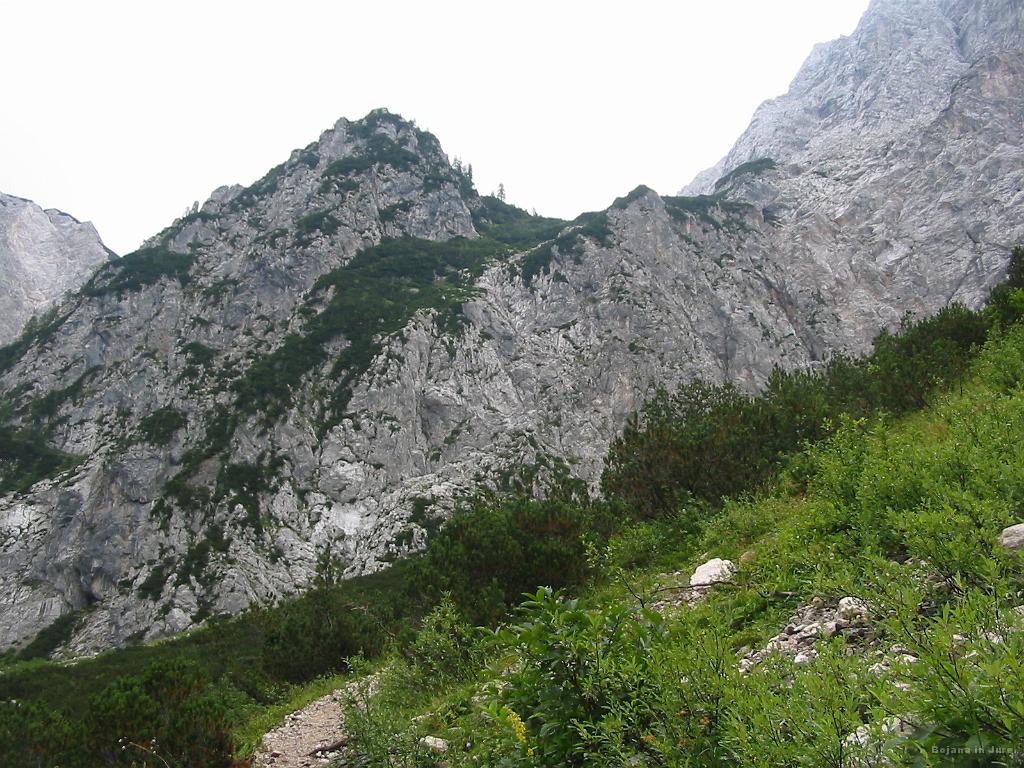 Slika_04.jpg - Levo v tem sedlu je Kranjska koča. Skrajno levo poteka lahka lovska pot, v gledani smeri je slovenska, skrajno desno pa skozi Žrelo.