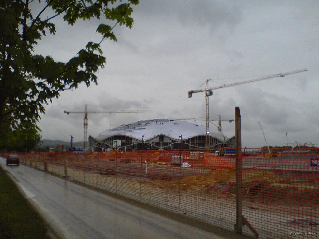 Slika_06.jpg - Poleg stadiona Ljubljana potrebuje tudi ogromno večnamensko dvorano, za preživetje pa nakupovalni center. Da se mudi je lepo videti, ker delavci v dežju pokrivajo streho. Smeško, kako je to kaj glede varnosti pri delu?