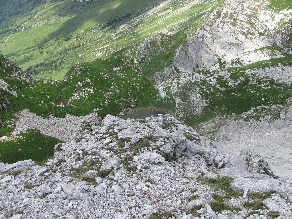 Slika_56.jpg - Pogled na jezero v Lužnici z vrha Škofiča (2013 m). Od tu ne najdeva ustrezne poti v dosedanji smeri, čeprav sva čez kako uro, ko sva bila že spodaj, videla dva planinca, ki sta s Škofiča prišla po najinih željah. Nič zato...