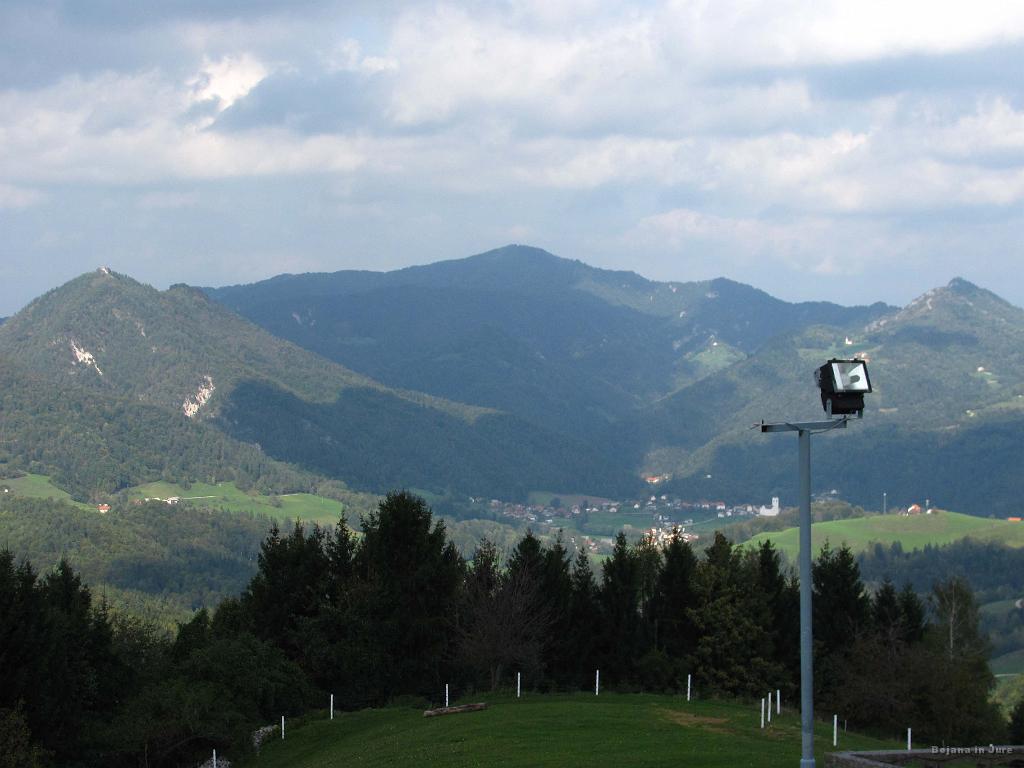 Slika_26.jpg - Pogled v smeri Polhovega Gradca. Levo Gora nad Polhovim Gradcem z značilno cerkvico, v sredini verjetno Tošč, desno pa polhograjska Grmada.